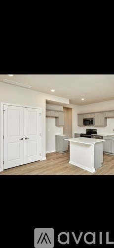 A modern kitchen with white cabinets and a central island.