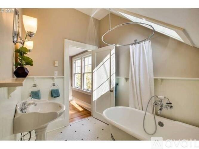 A bathroom with a white tub and a shower with a white curtain.