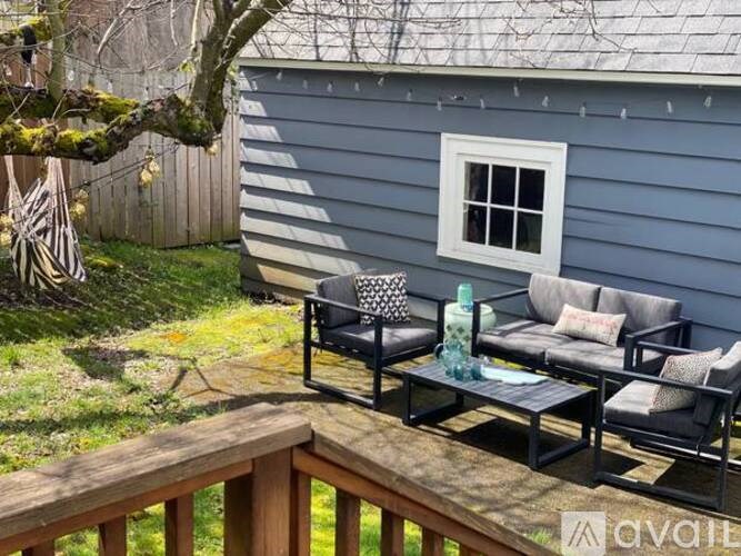 A patio with a table and chairs and a blue house in the background.