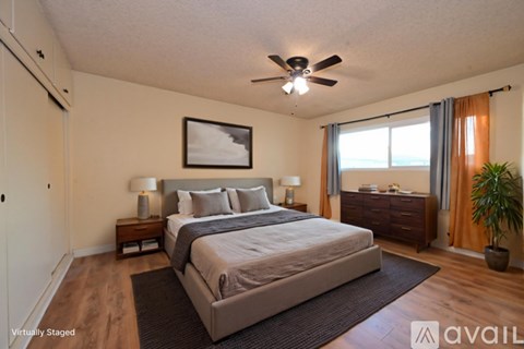 A bedroom with a large bed and a ceiling fan.