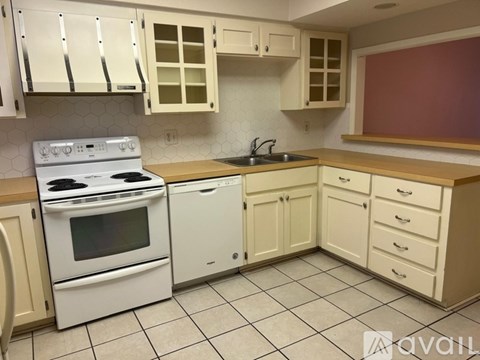A kitchen with white appliances and cabinets.