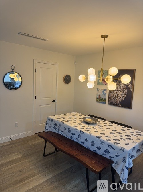 A bedroom with a bed, bench, and a wall-mounted mirror.