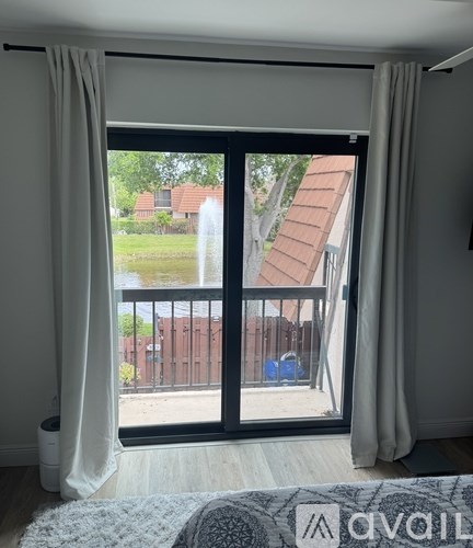 A balcony with a view of a garden and houses.
