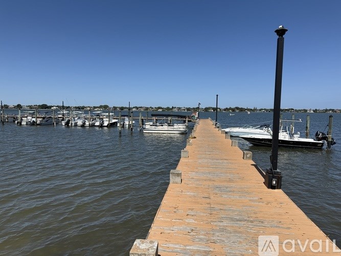 A wooden pier extends into a body of water with boats docked at the end.