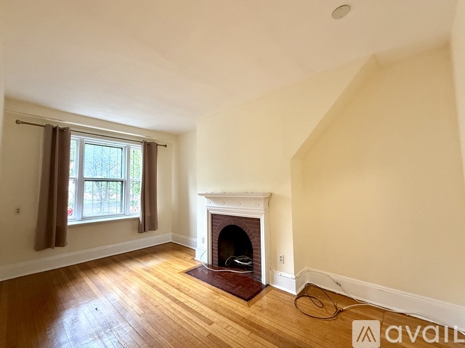 A living room with a fireplace, a chair, a couch, a coffee table, and a TV.