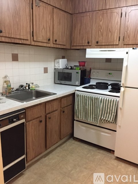 A kitchen with wooden cabinets and a white fridge.