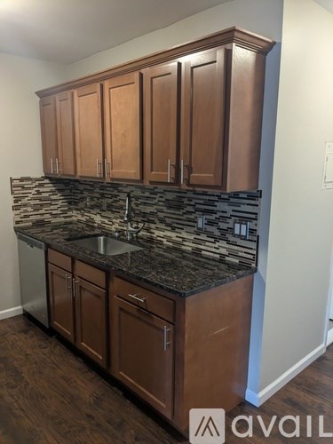 A kitchen with brown cabinets and a stone countertop.