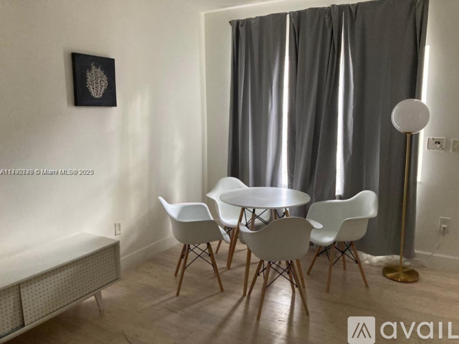 A dining room with a white table and chairs.
