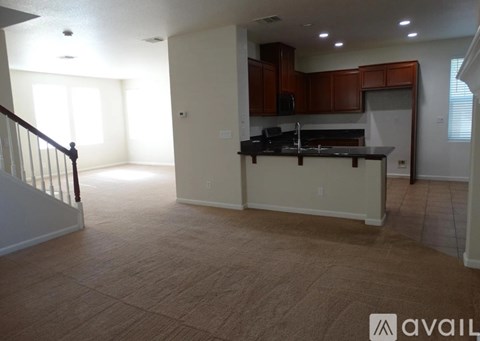 A kitchen with wooden cabinets and a black countertop is available for rent.