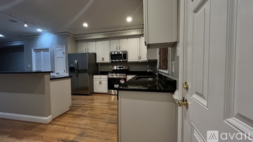 A kitchen with a black fridge and stove top oven.