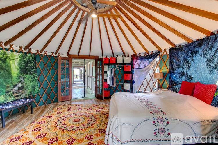 A bedroom with a large bed and a yurt-like ceiling.