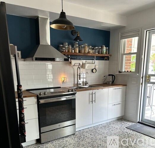 A kitchen with a stove top oven and a range hood.