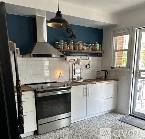 A kitchen with a stove top oven and a range hood.