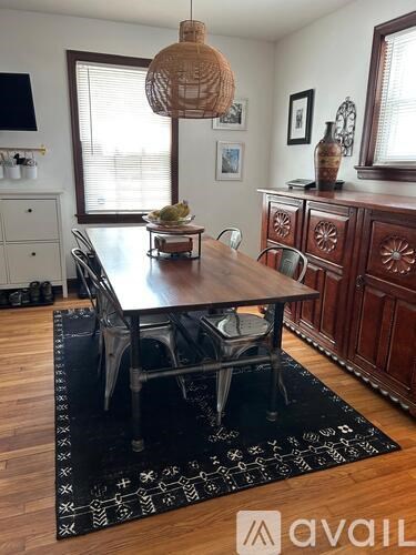 A dining room with a wooden table and chairs.