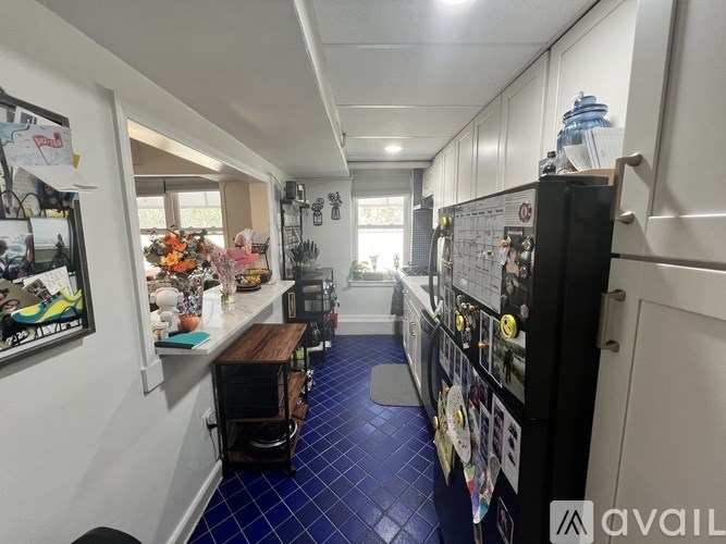 A kitchen with a blue tile floor and white walls.