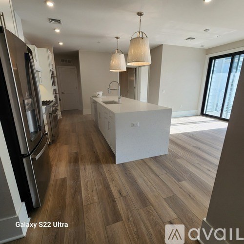 A kitchen with wooden floors and a white island.
