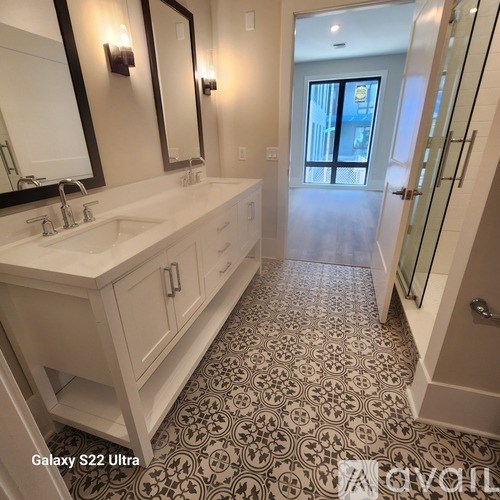 A bathroom with a black and white floor and a white sink.