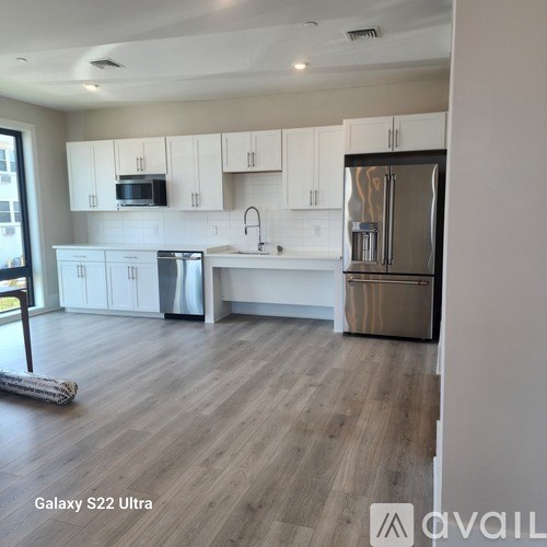 A kitchen with white cabinets and a refrigerator.