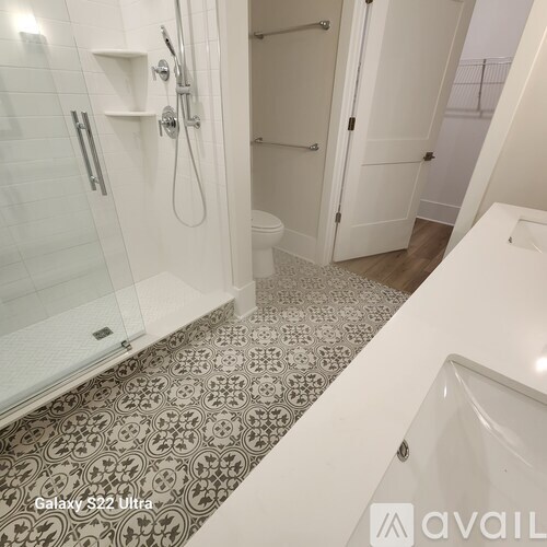 A bathroom with a Galaxy S22 Ultra phone on the floor.