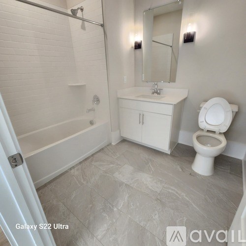 A white bathroom with a toilet, sink, and bathtub.