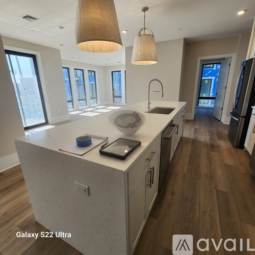 A modern kitchen with a large island and pendant lighting.
