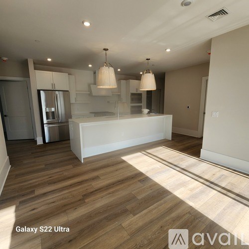 A kitchen with wooden floors and white walls.