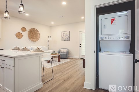 A kitchen with white cabinets and a white fridge with a red logo on it.