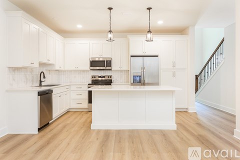 A kitchen with white cabinets and a wooden floor.