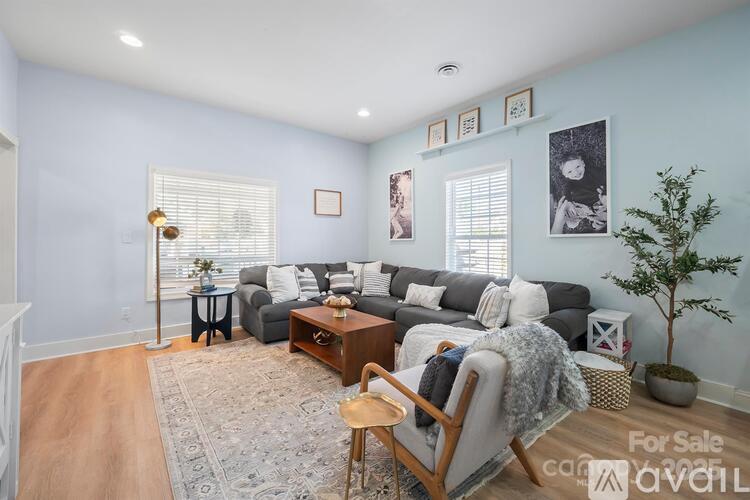 A living room with a grey couch and a wooden chair.