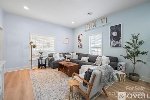 A living room with a grey couch and a wooden chair.