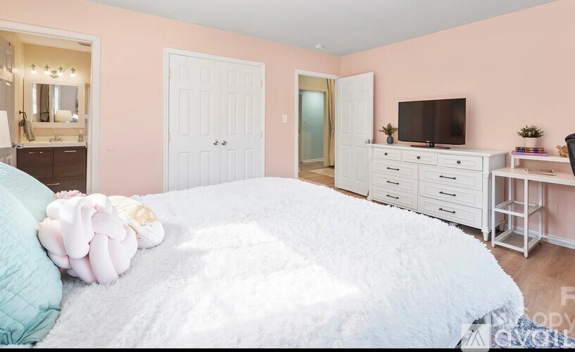 A bedroom with a bed, dresser, and mirror.