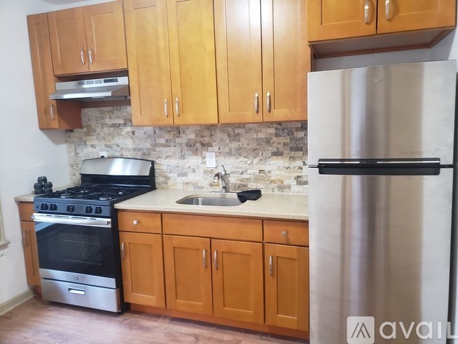 A kitchen with wooden cabinets and a stainless steel refrigerator.