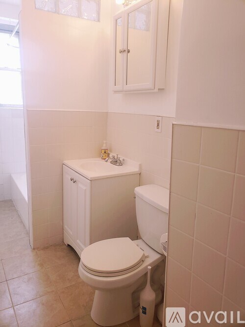 A white toilet in a small bathroom with tiled walls.