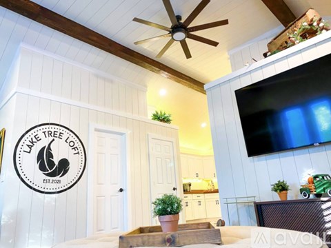 A living room with a logo on the wall that says Lake Tree Loft.