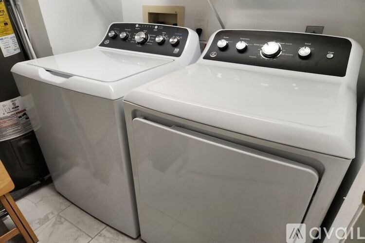 A pair of front loading washing machines in a laundry room.