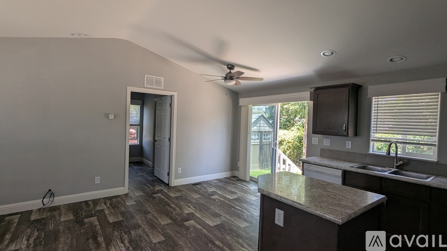 A kitchen with a fan on the ceiling and a counter with a sink.