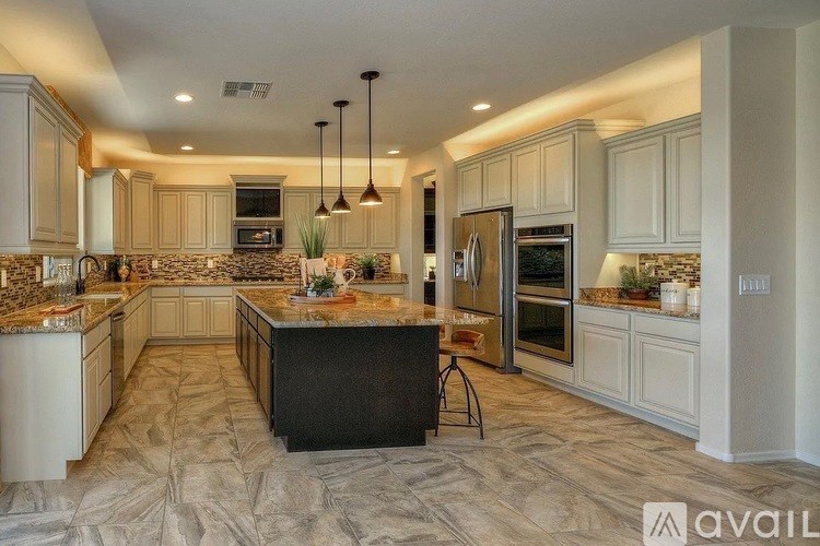 A kitchen with a marble countertop and a center island.