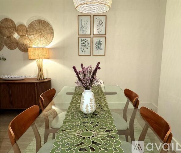 A dining table with a vase of flowers in the middle.