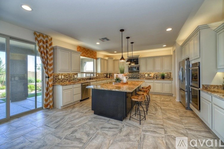 A kitchen with a marble countertop and a black island.
