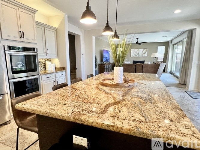 A living room with a white couch, a wooden table, and a chandelier.