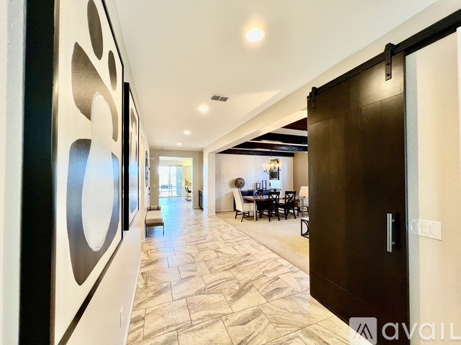 A hallway with a patterned floor leads to a dining area.