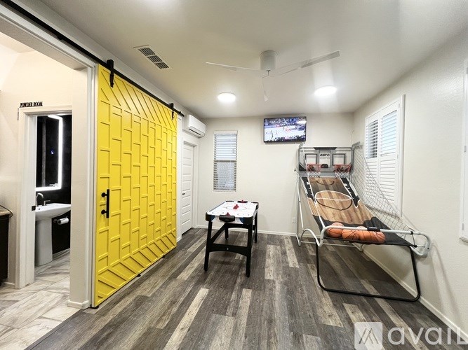 A room with a yellow door and a bed.