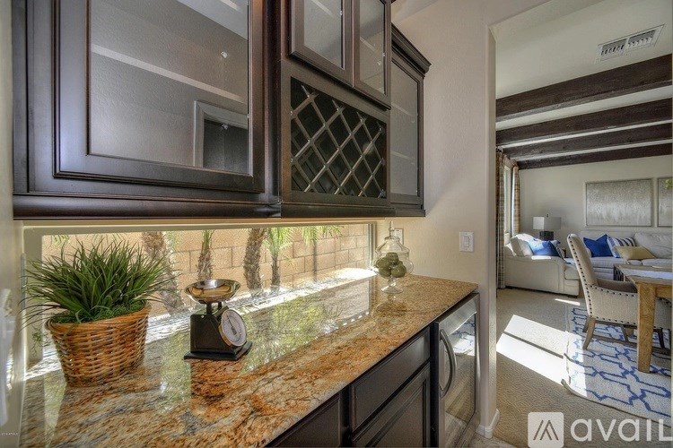 A kitchen with granite countertops and a view of a backyard.