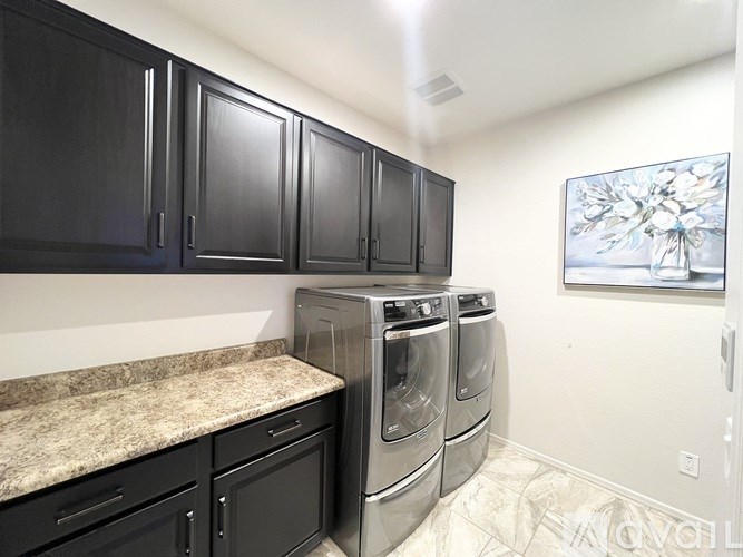 A kitchen with black cabinets and a marble countertop.