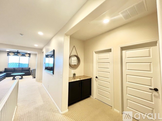 A hallway with a white door and a black counter.