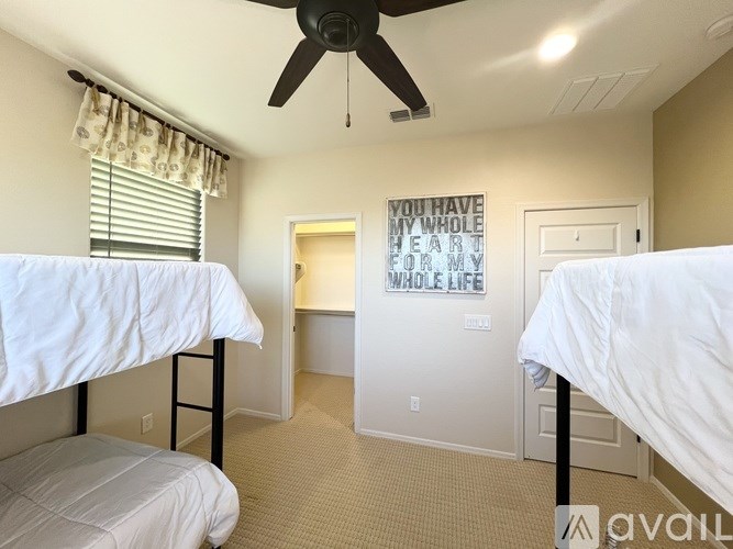 A bedroom with two beds and a ceiling fan.