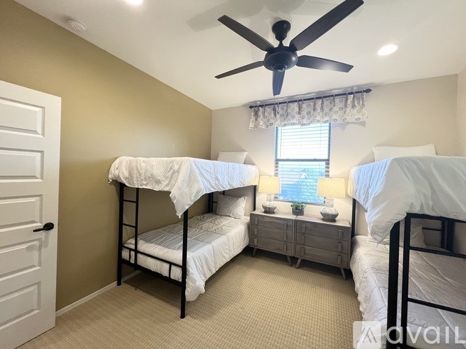 A room with two bunk beds and a ceiling fan.