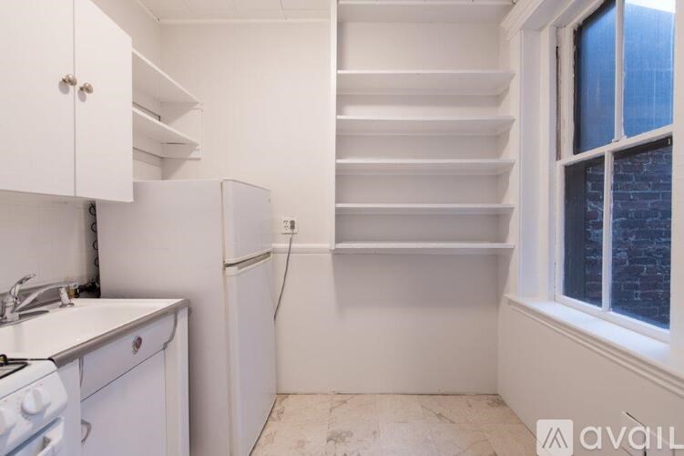 A kitchen with white appliances and cabinets.