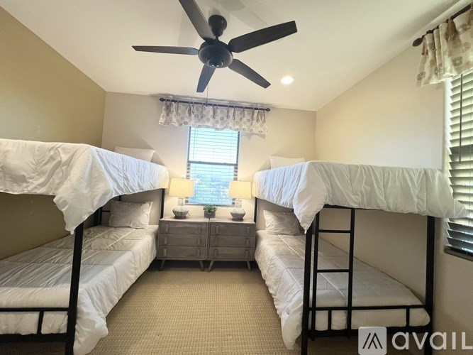 A room with two bunk beds and a ceiling fan.