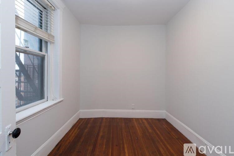 A room with a wooden floor and a window.